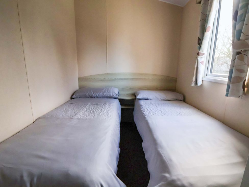 A bedroom with two single beds and a window at Dunes View in Prestatyn