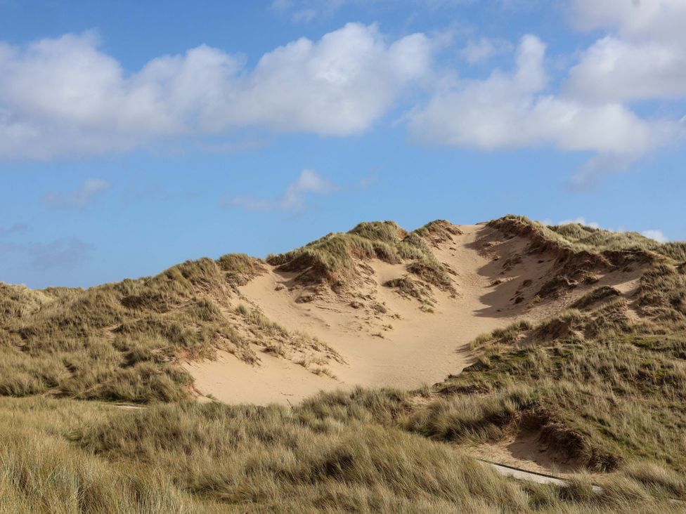 Sand dunes with grass under a blue sky at Dunes View in Prestatyn