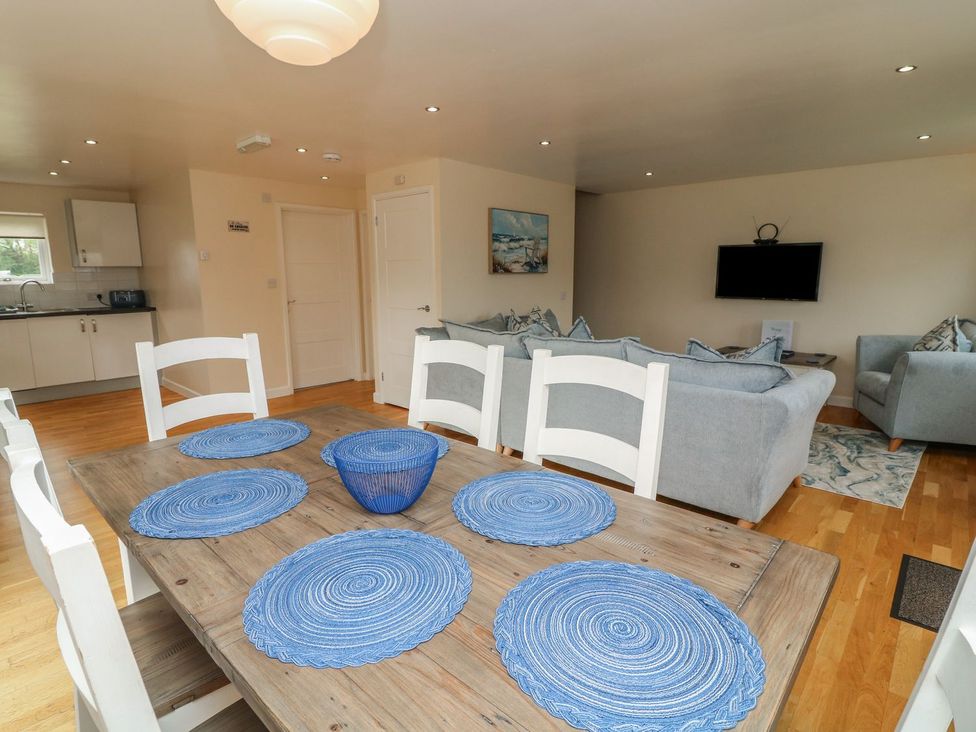 A dining room with a wooden table and blue placemats at James Ville Marina Lodge 21 in Brigg