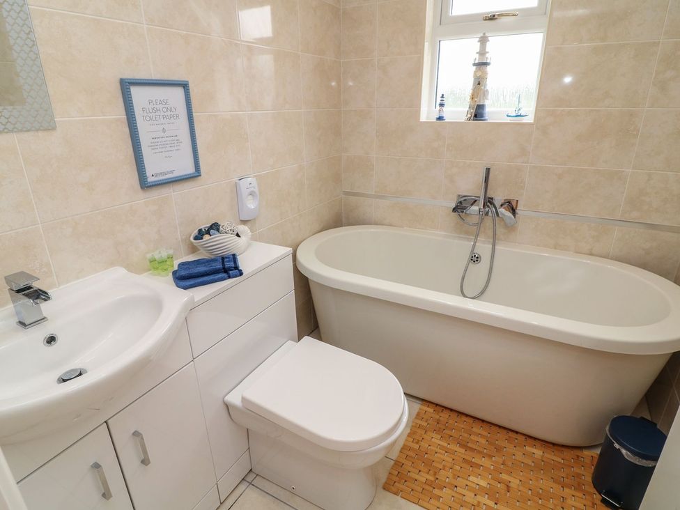 A bathroom with a bathtub, sink and toilet at James Ville Marina Lodge 21 in Brigg