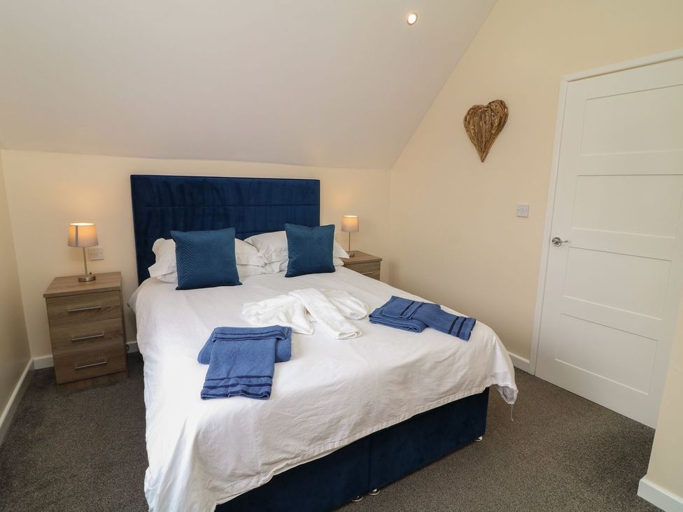 A bedroom with a bed and bedside tables at James Ville Marina Lodge 21 in Brigg