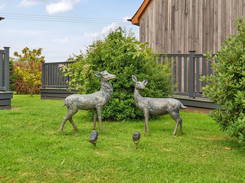 Two deer statues near bushes and grass at James Ville Marina Lodge 21 in Brigg