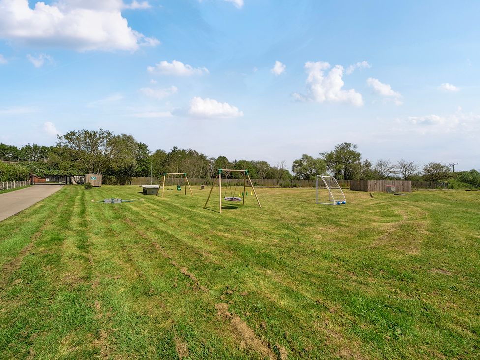 An outdoor area with swings and goalposts at James Ville Marina Lodge 21 in Brigg