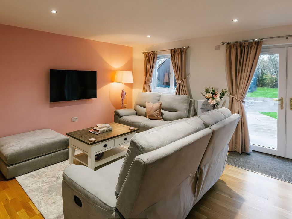 A living room with a sofa and television at James Ville Marina Lodge 23 in Brigg