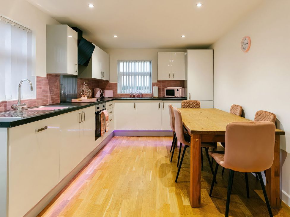 A kitchen with cabinets and a dining table at James Ville Marina Lodge 23 in Brigg