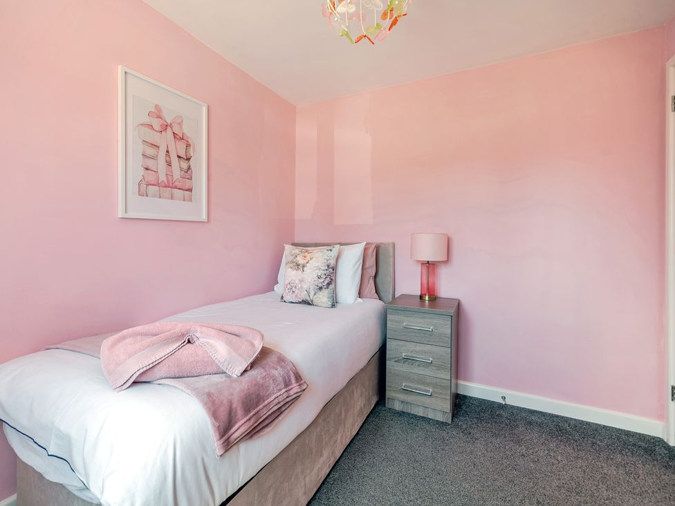 A bedroom with a single bed and nightstand at James Ville Marina Lodge 23 in Brigg