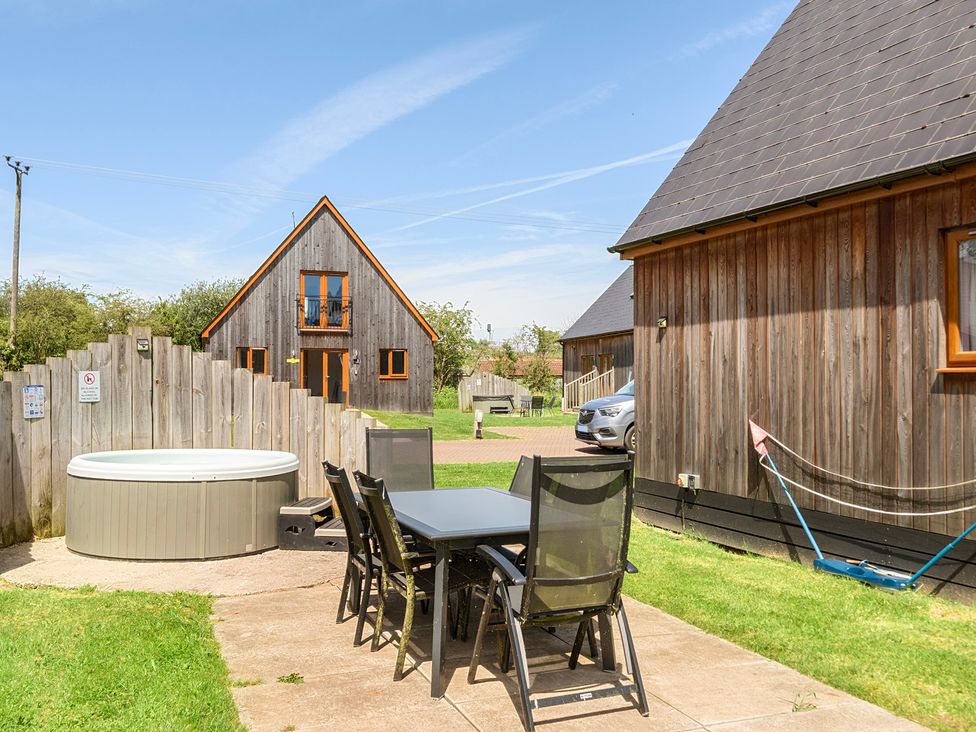 An outdoor area with a table, chairs, hot tub, and houses at James Ville Marina Lodge 23, Brigg