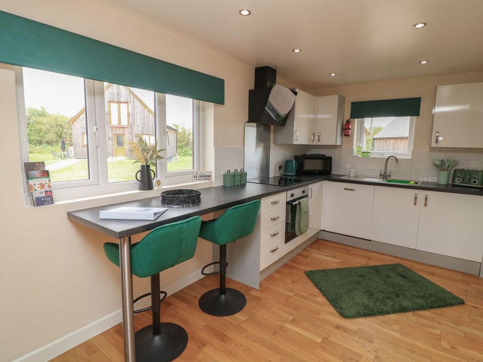 A kitchen with bar stools at James Ville Marina Lodge 22 in Brigg