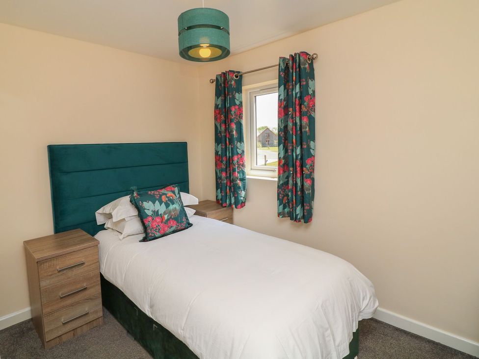 A bedroom with a bed and curtains at James Ville Marina Lodge 22 in Brigg