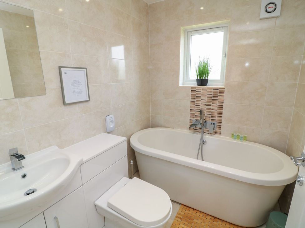 A bathroom with a bathtub, sink, and toilet at James Ville Marina Lodge 22 in Brigg