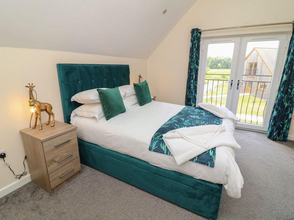 A bedroom with a bed and bedside table at James Ville Marina Lodge 22 in Brigg
