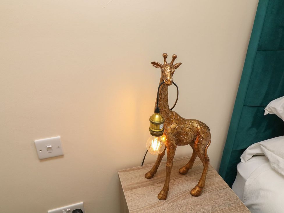 A giraffe-shaped lamp on a bedside table at James Ville Marina Lodge 22, Brigg