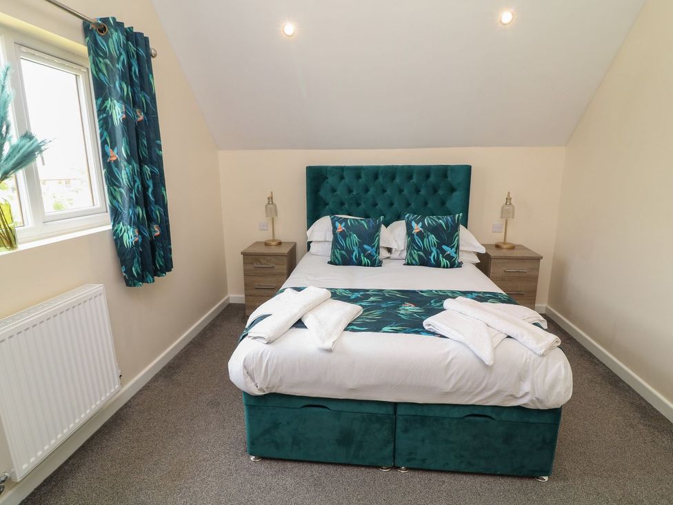 A bedroom with a bed and bedside tables at James Ville Marina Lodge 22 in Brigg