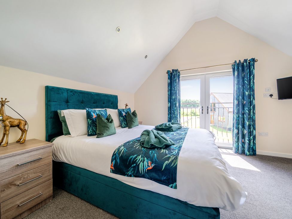 A bedroom with a bed and sliding doors at James Ville Marina Lodge 22 in Brigg
