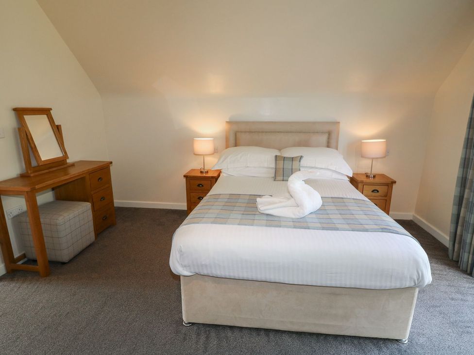 A bedroom with a bed and dressing table at James Ville Marina Lodge 10 in Brigg
