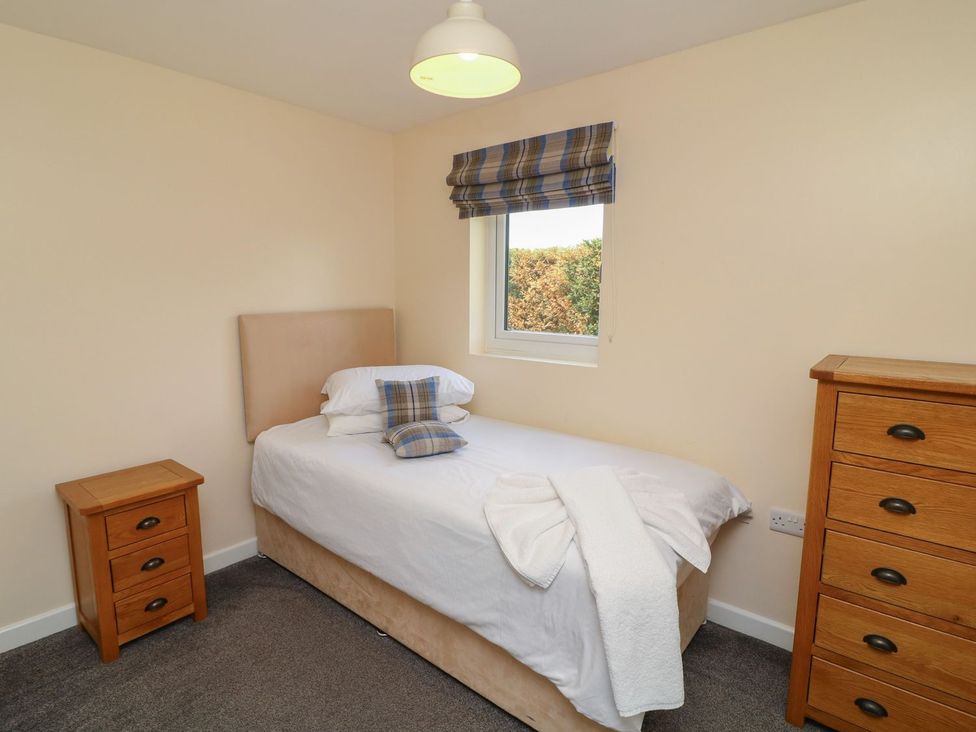 A bedroom with a single bed and a dresser at James Ville Marina Lodge 10 in Brigg