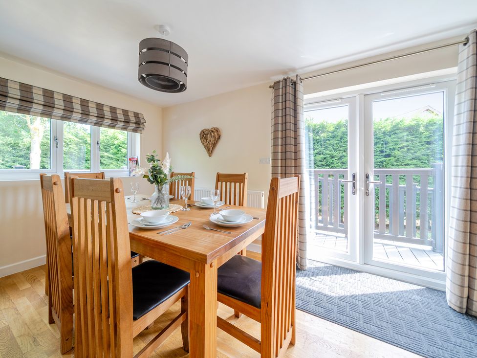 A dining room with a wooden table and chairs at James Ville Marina Lodge 10 in Brigg