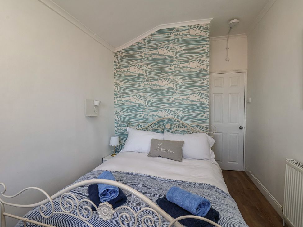 A bedroom with a bed and towels on the blanket at Apartment 2 in Scarborough