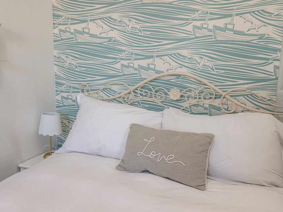 A bedroom with a bed and decorative pillow at Apartment 2 in Scarborough