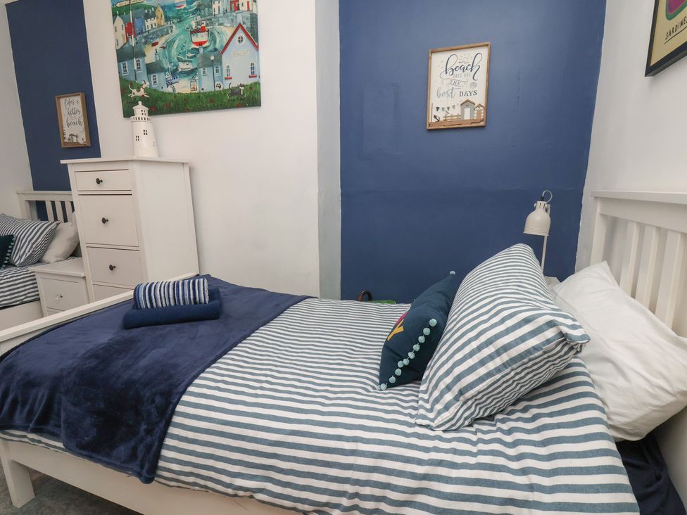 A bedroom with a bed and a painting at Apartment 2 in Scarborough