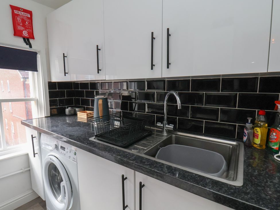 A kitchen with a washing machine and sink at Apartment 3 in Scarborough