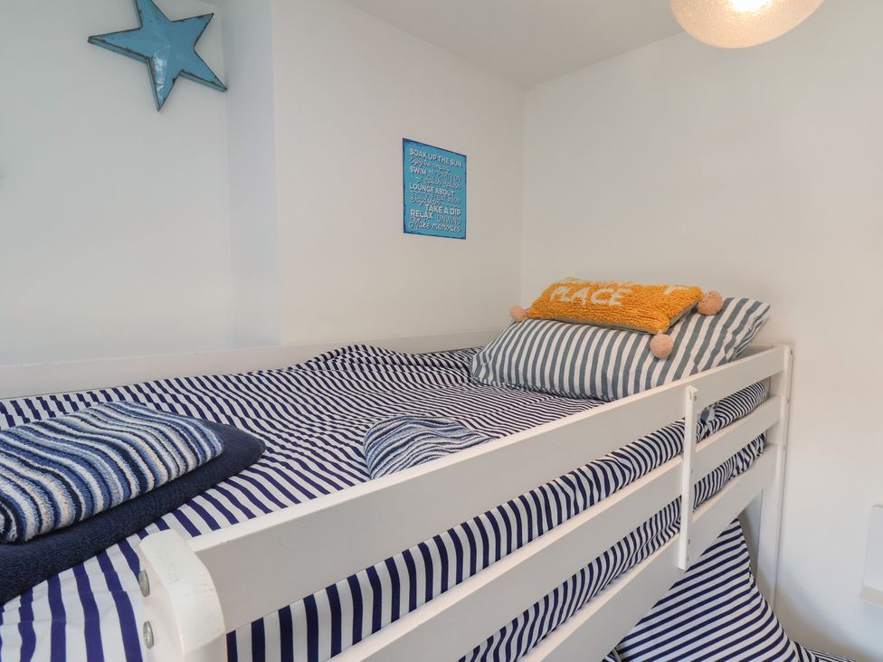 A bunk bed with striped bedding and decorative pillows at Apartment 3 in Scarborough