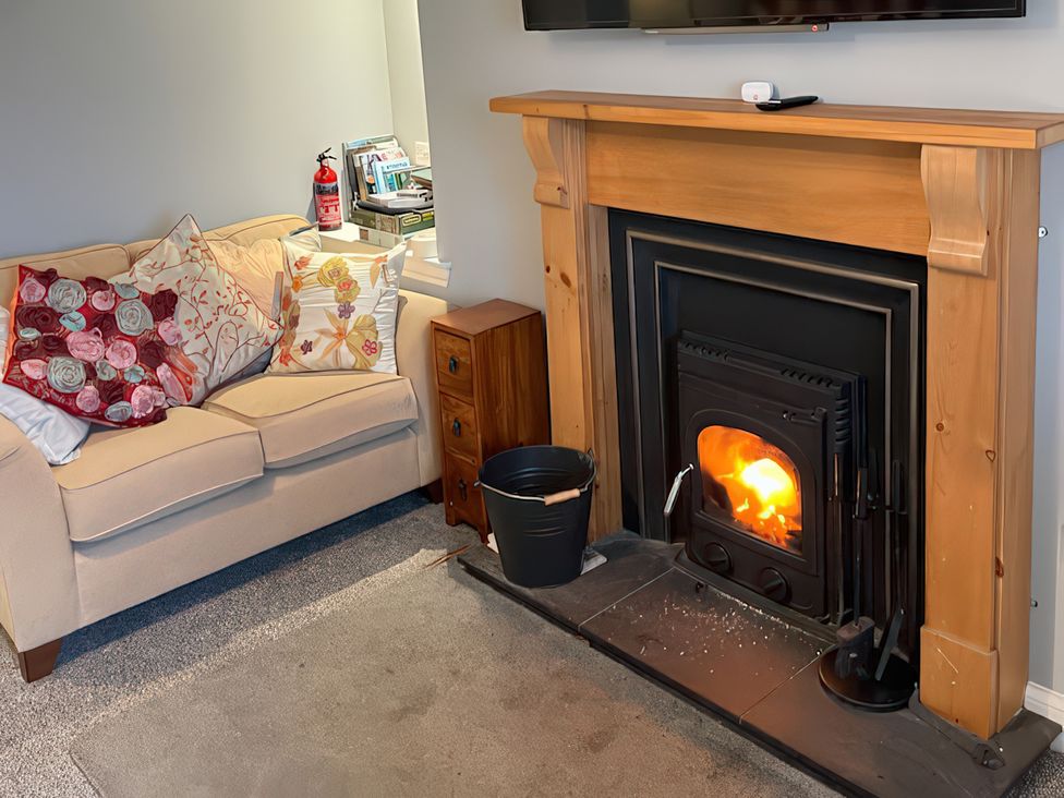 A living room with a sofa and fireplace at 15 New Shawbost in Shawbost