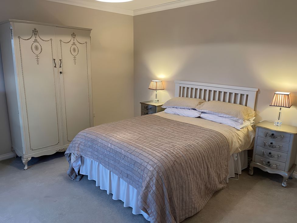 A bedroom with a bed and nightstands at 15 New Shawbost in Shawbost