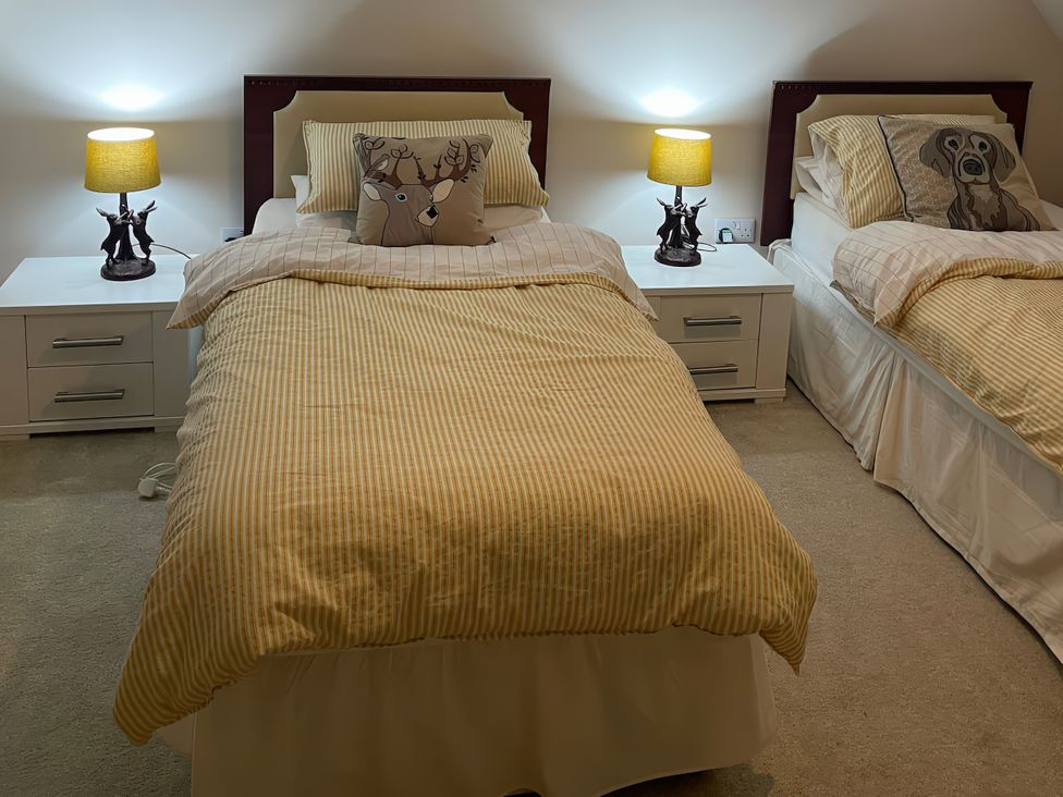 A bedroom with two beds and lamps at 15 New Shawbost in Shawbost