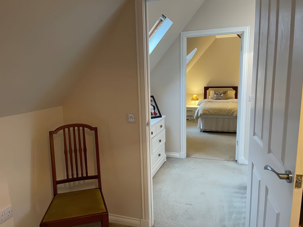 A bedroom with a bed and dresser, viewed from a hallway at 15 New Shawbost in Shawbost