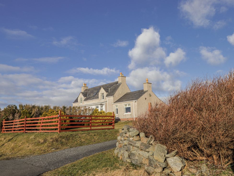 A house with a red fence and a pathway at 15 New Shawbost in Shawbost