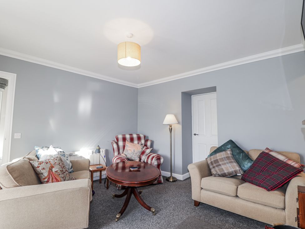 A living room with a table and seating at 15 New Shawbost in Shawbost