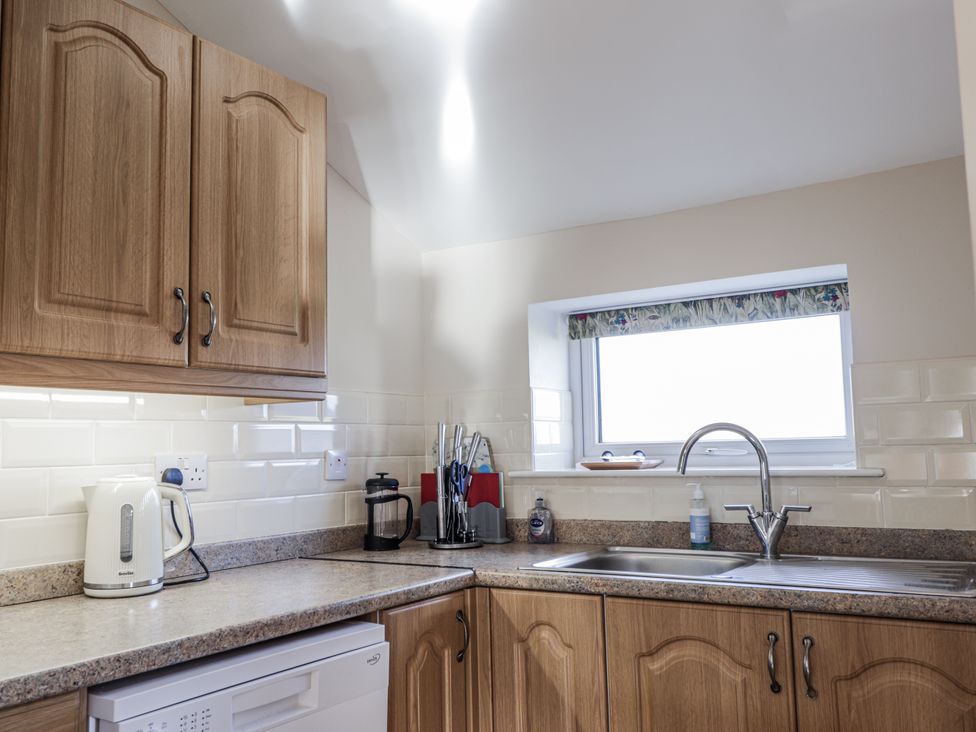 A kitchen with a sink, kettle, and countertop at 15 New Shawbost in Shawbost
