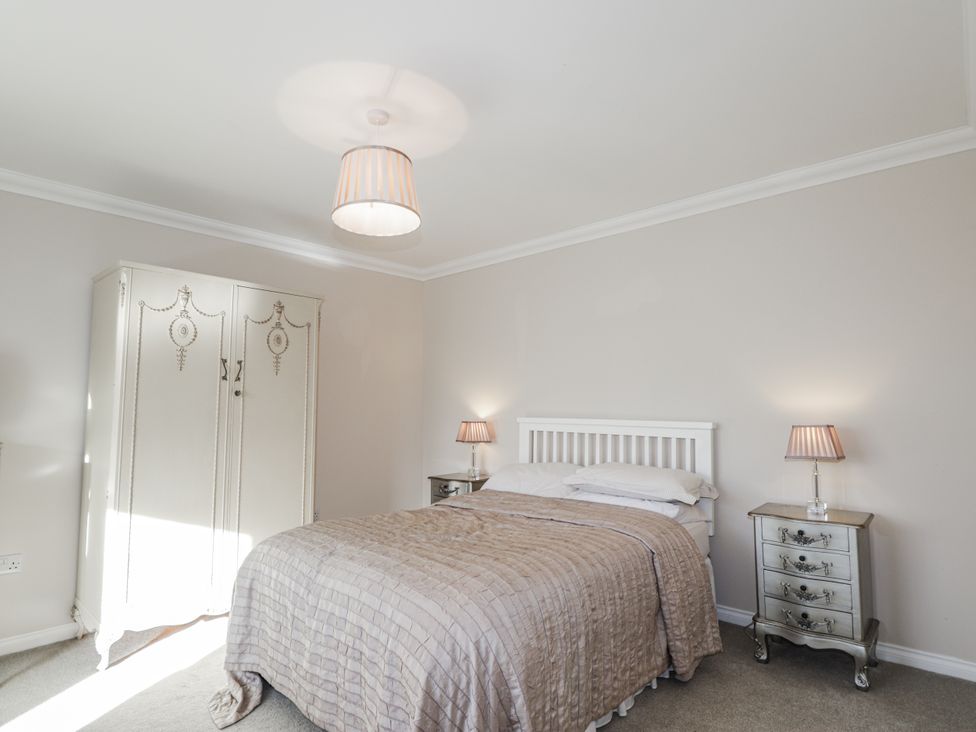 A bedroom with a bed and wardrobe at 15 New Shawbost in Shawbost