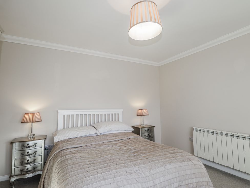 A bedroom with a bed and nightstands at 15 New Shawbost in Shawbost