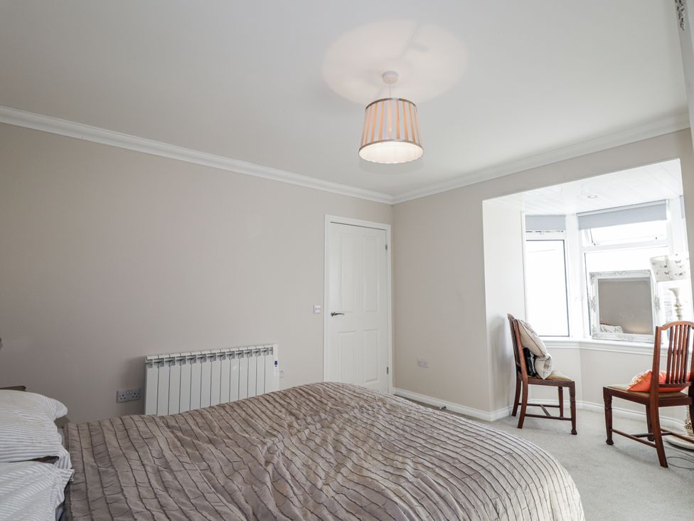 A bedroom with a bed and a chair at 15 New Shawbost in Shawbost