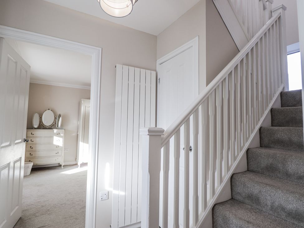 A hallway with a staircase and door at 15 New Shawbost in Shawbost