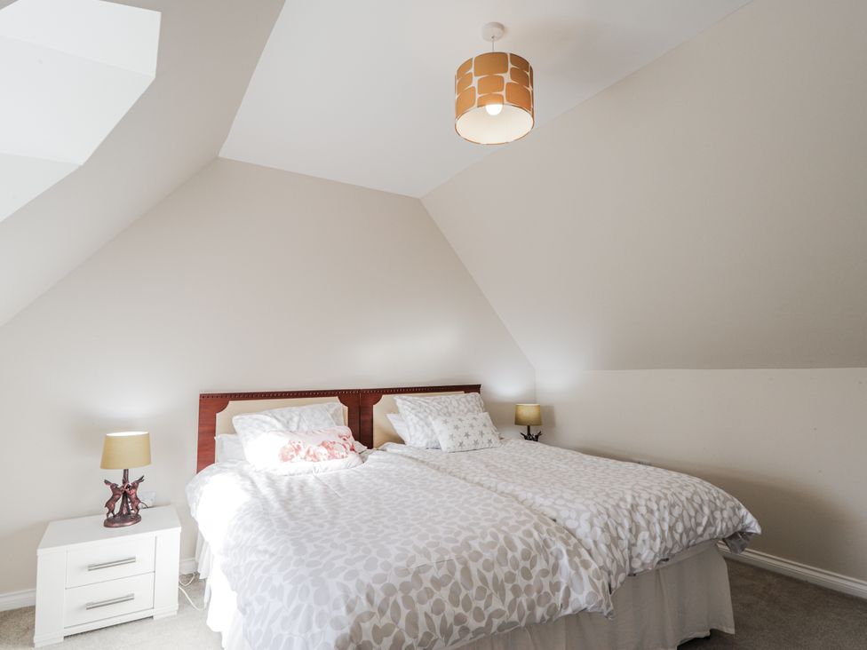 A bedroom with two beds and a nightstand at 15 New Shawbost in Shawbost