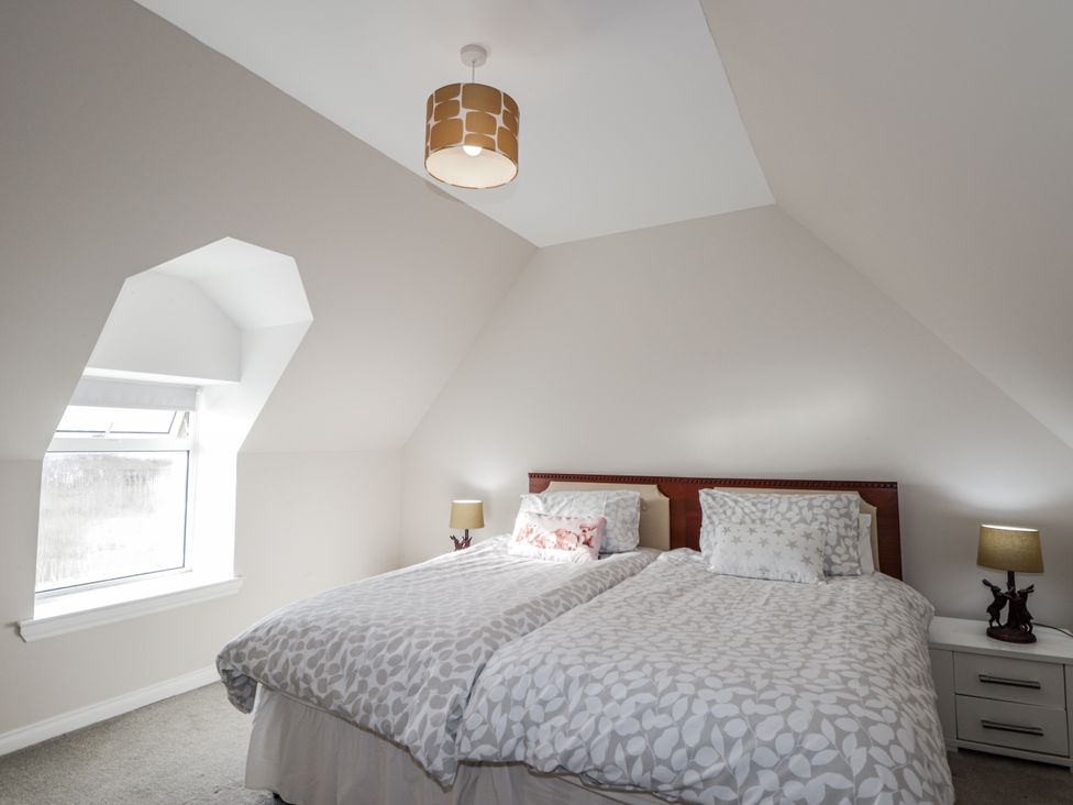 A bedroom with two beds and a window at 15 New Shawbost in Shawbost