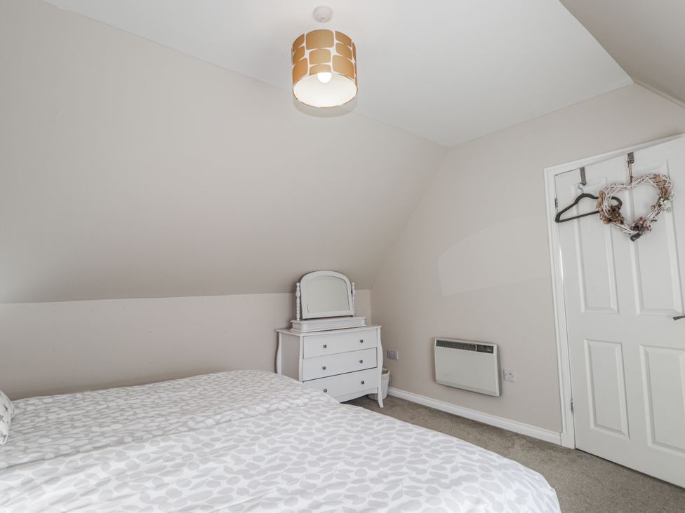 A bedroom with a bed, dresser and mirror at 15 New Shawbost in Shawbost