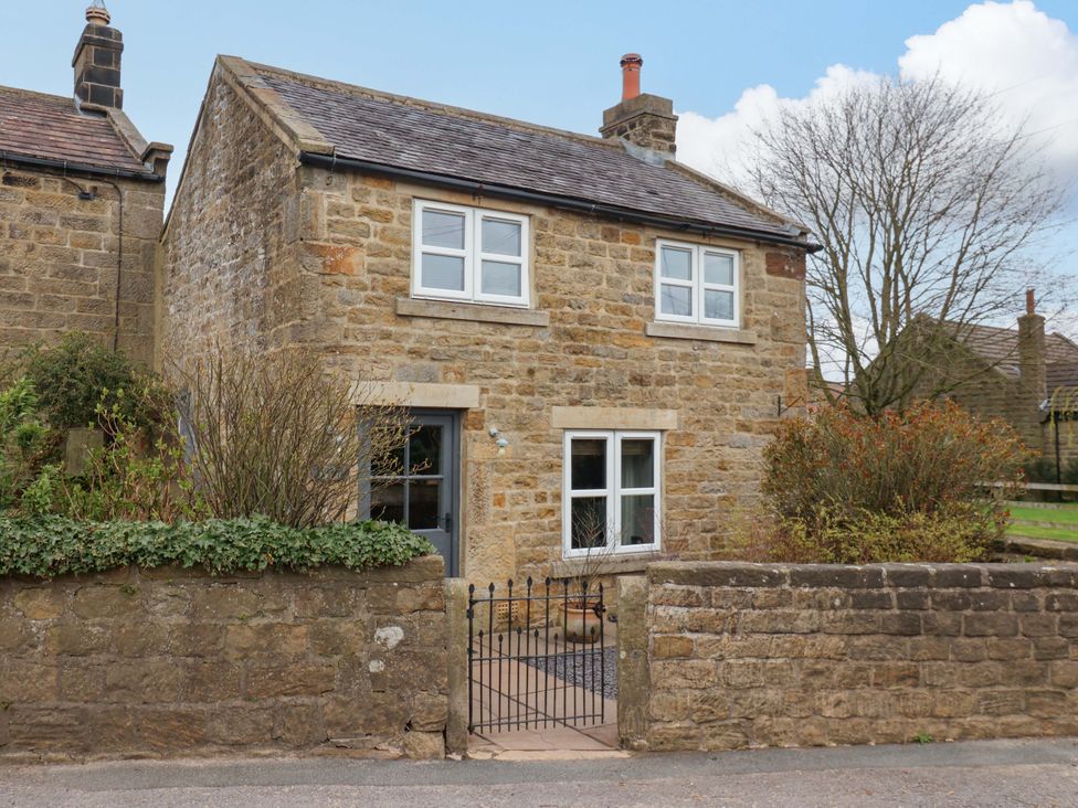 A house with stone walls and a gate at The Green in Sawley near Ripon