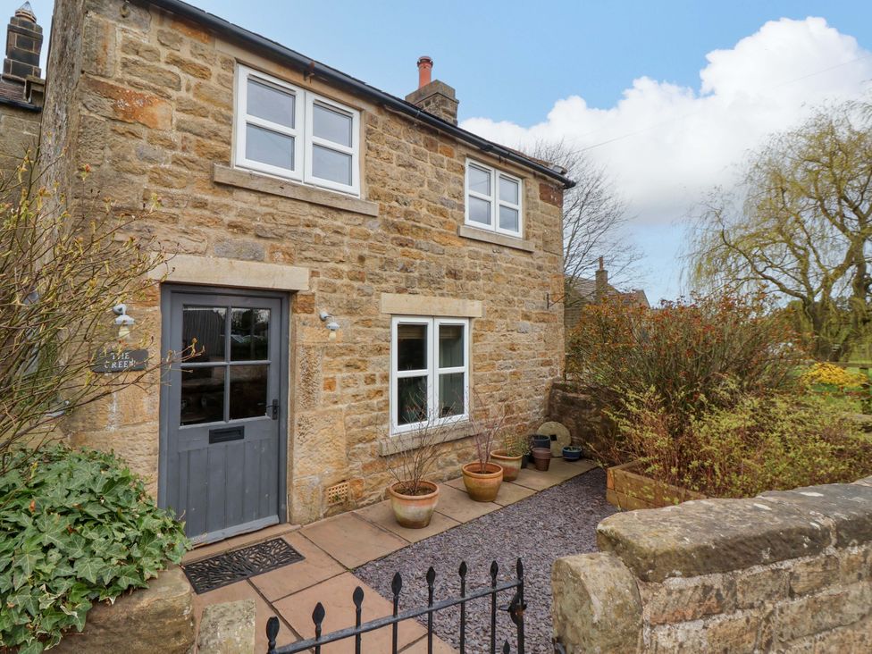 A stone house with front door and planters at The Green in Sawley near Ripon