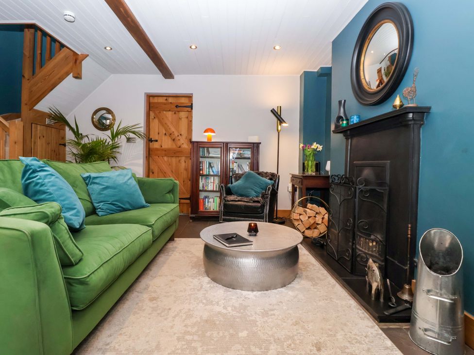 A living room with a green sofa and bookshelf at The Green in Sawley near Ripon