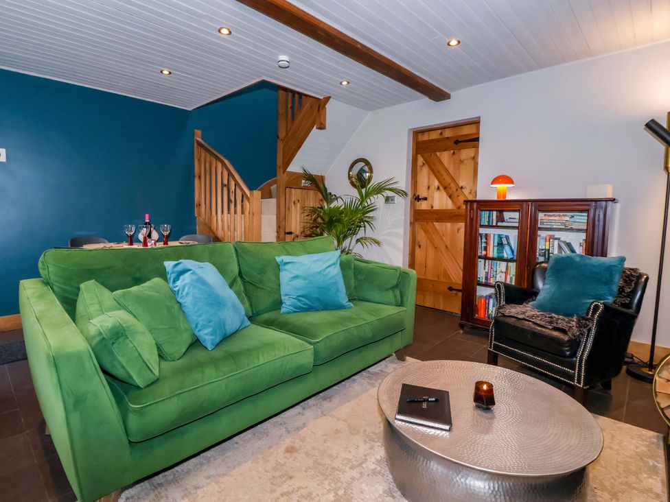 A living room with a green sofa and coffee table at The Green in Sawley near Ripon