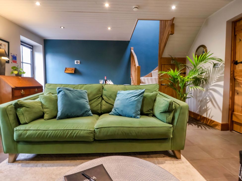 A living room with a green sofa and a coffee table at The Green in Sawley near Ripon