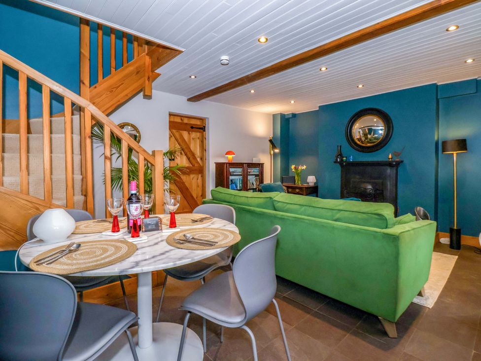 A living room with a green sofa and dining table at The Green in Sawley near Ripon