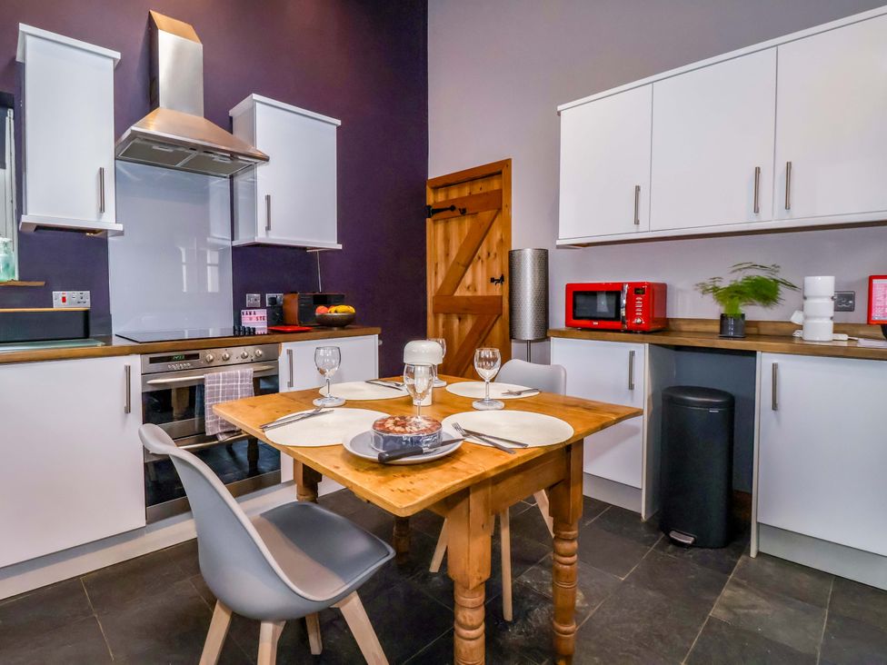 A kitchen with a dining table and appliances at The Green in Sawley near Ripon