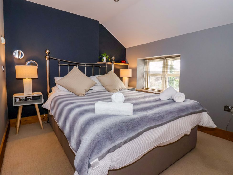 A bedroom with a bed and nightstand at The Green in Sawley near Ripon
