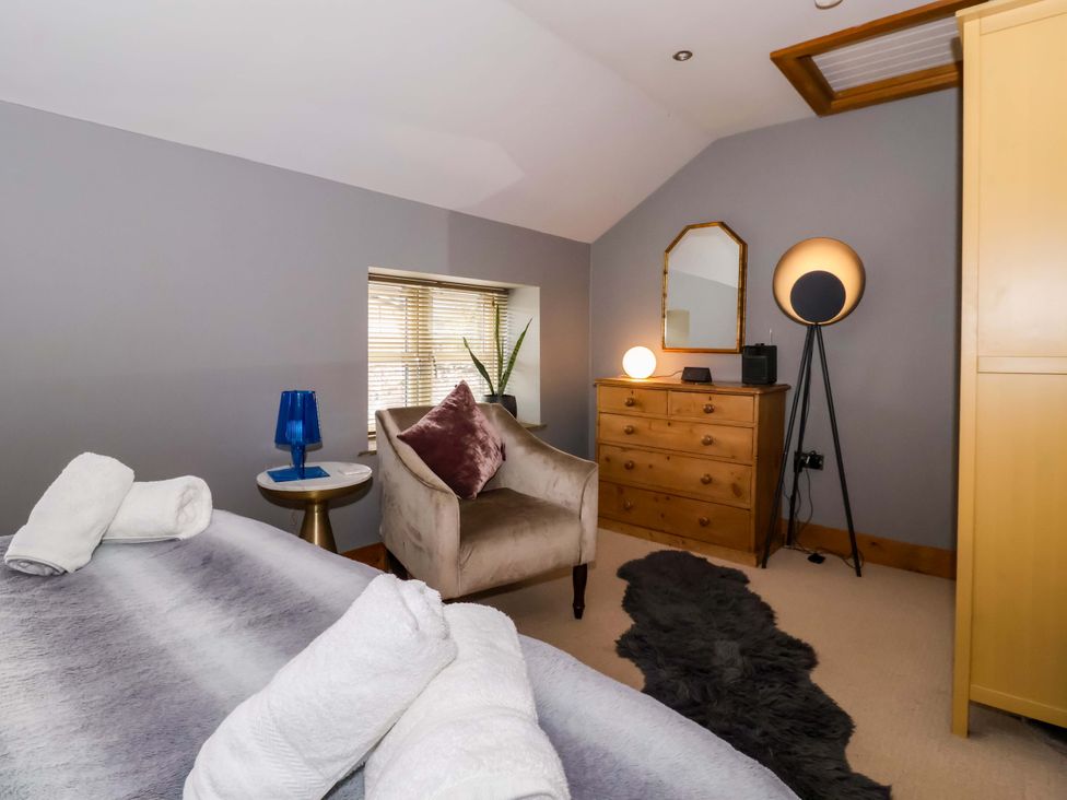 A bedroom with a bed and wooden dresser at The Green in Sawley near Ripon