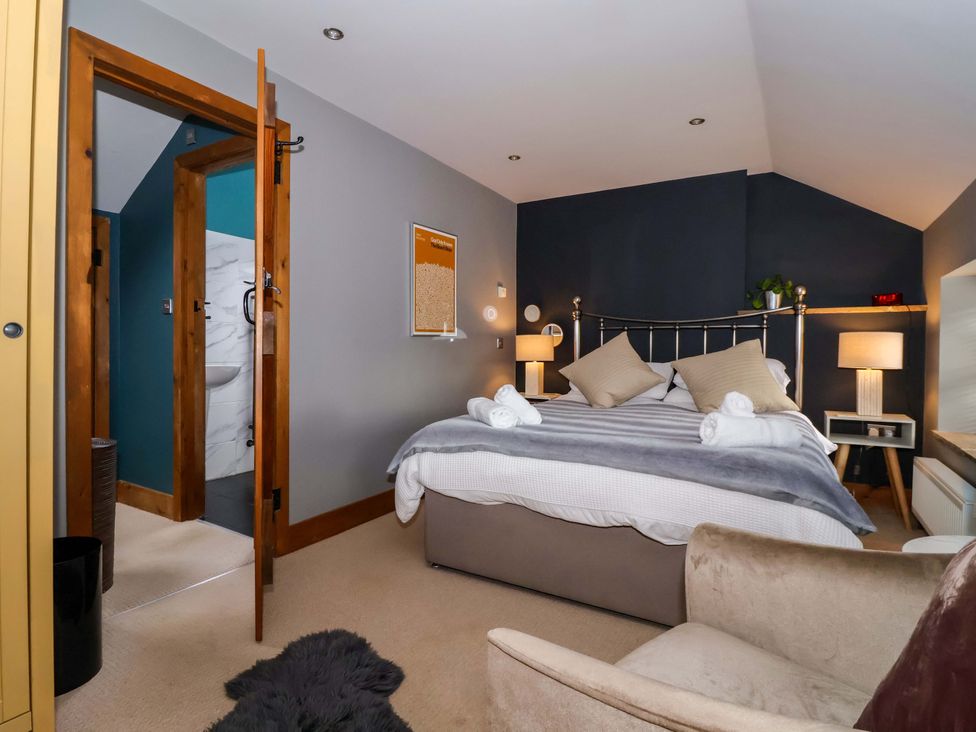 A bedroom with a bed and armchair at The Green Sawley near Ripon